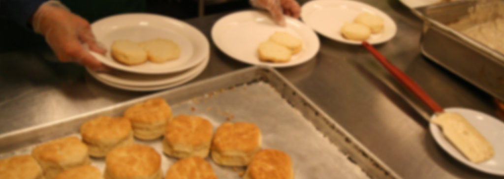 Homemade biscuits on white plates and a baking tray, representing a shared breakfast event or food ministry gathering at the church.