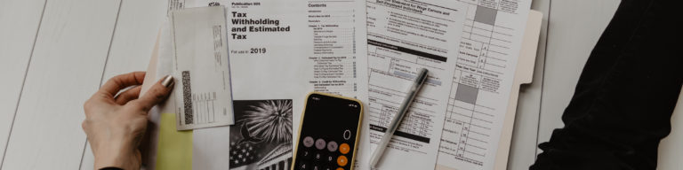 Tax documents titled Publication 505 'Tax Withholding and Estimated Tax for use in 2019' spread on white desktop with calculator, pen, sticky notes, and tax forms including Form 4029 and Schedule C.