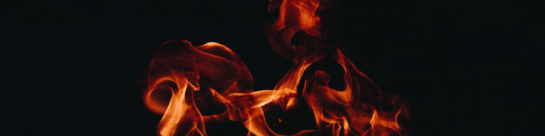 Pentecost flaming tongues of fire graphic design with orange and red flames against black background, representing the Holy Spirit.