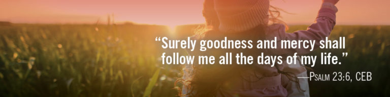 Inspirational banner with sunset field landscape and person with raised arms, featuring Psalm 23:6 CEB quote: "Surely goodness and mercy shall follow me all the days of my life."