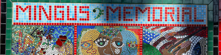 Colorful mosaic mural with pixelated text reading 'MINGLES 2 MEMORIAL' featuring abstract mosaic artwork of faces and patterns.