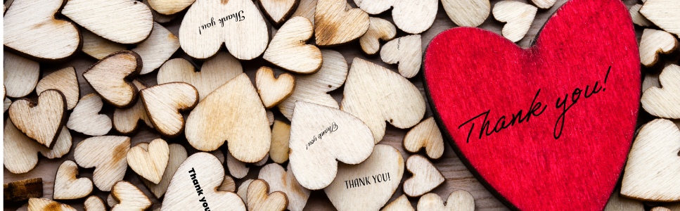 Red heart with 'Thank you' text on wooden heart background.