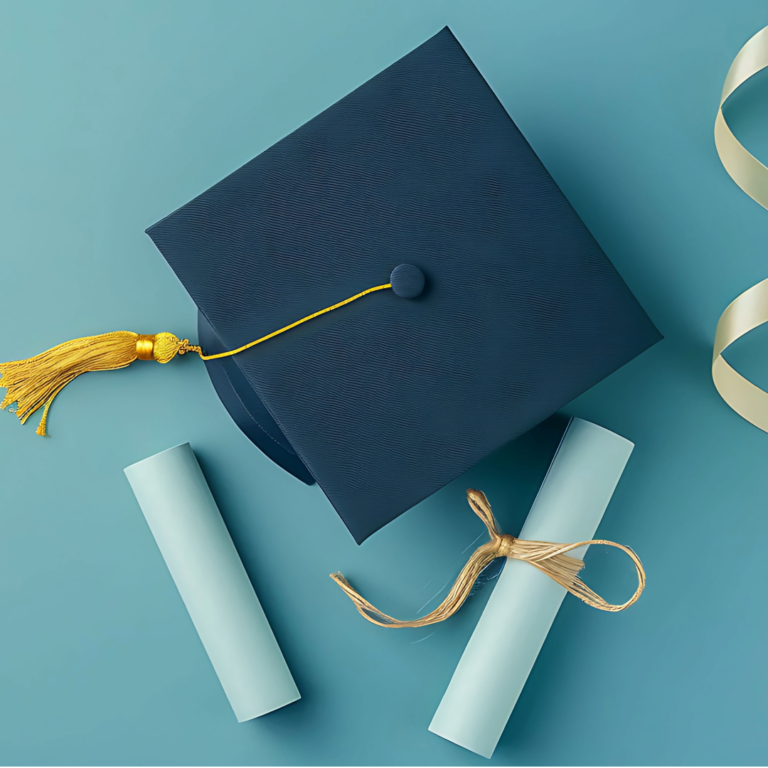 A navy graduation cap with gold tassel beside rolled diplomas, celebrating this year's graduates