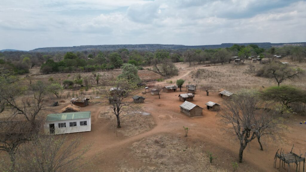 Aerial view of a rural village surrounded by dry land and scattered trees in Malawi